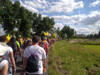 Pielgrzymka na tle kościoła w Miedźnie