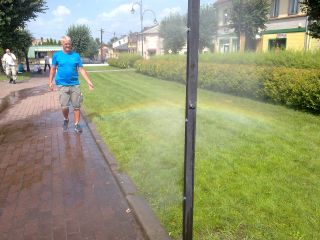 Na rynku w Warcie stała instalacja kurtyny wodnej (identyczna jest po drugiej stronie rynku), przez którą przechodzi brat Mietek